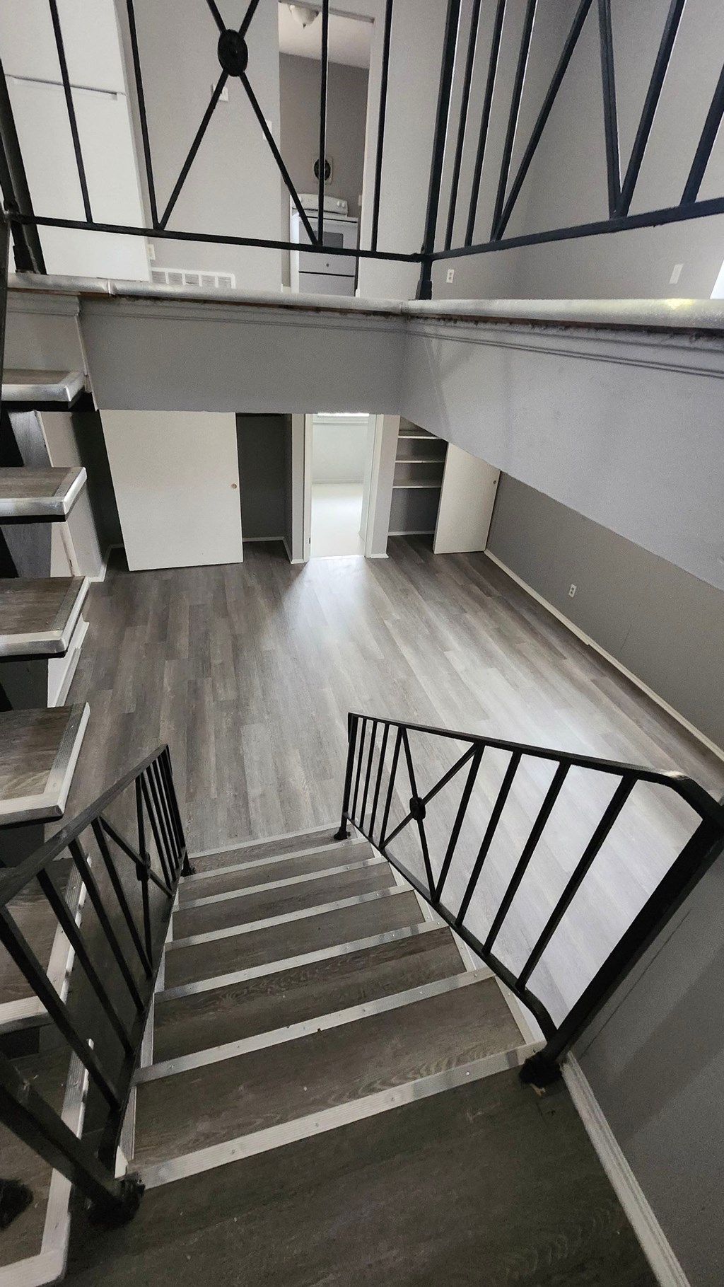 A staircase with a black metal railing and wooden steps.