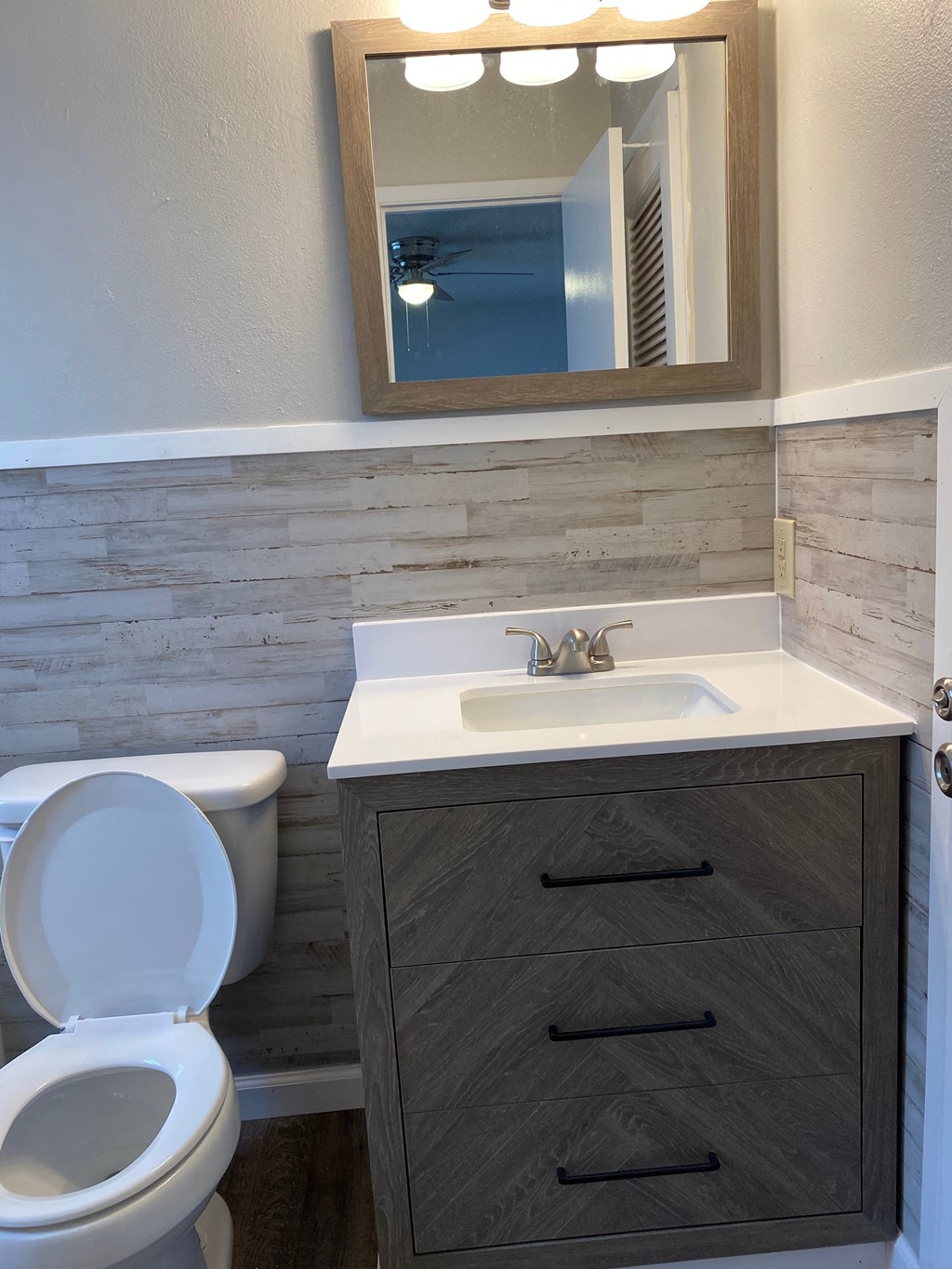 a bathroom with a toilet and a sink and a mirror