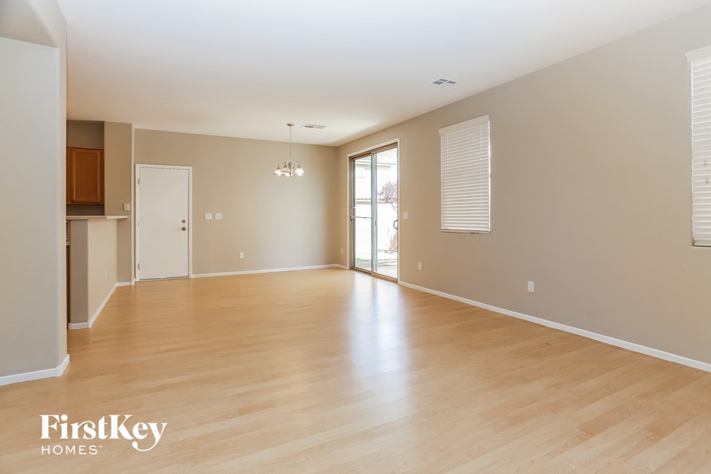 the living room and dining room of an empty house with wood flooring