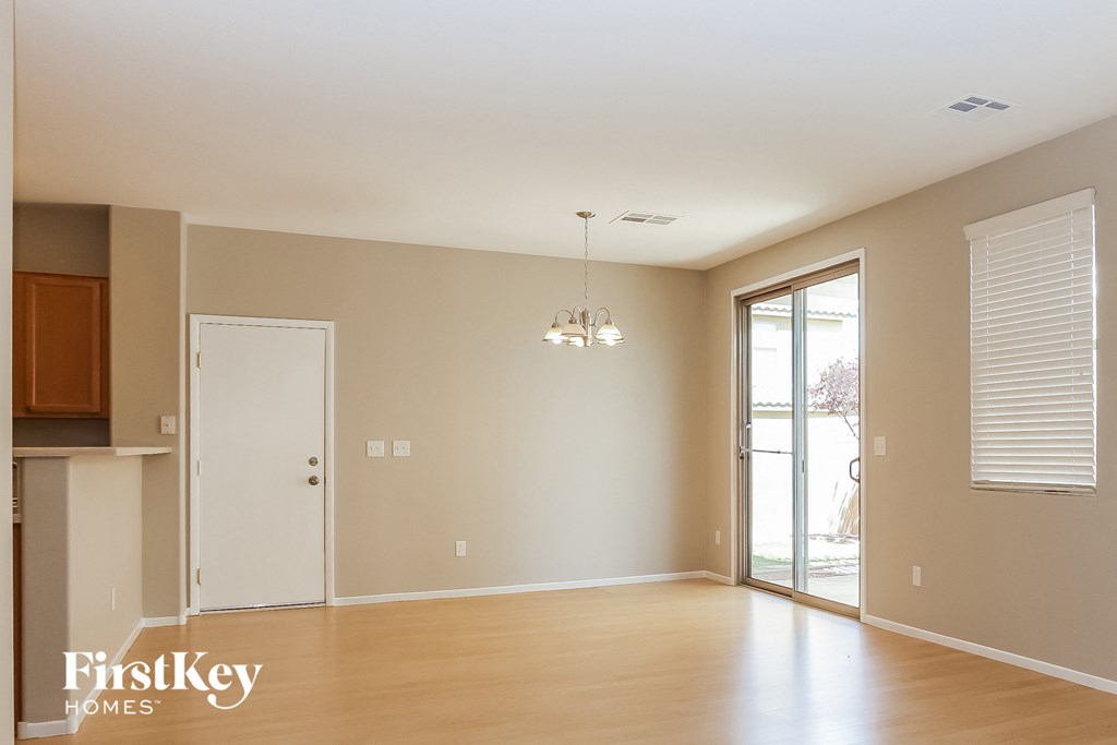 an empty living room with wood flooring and a sliding glass door