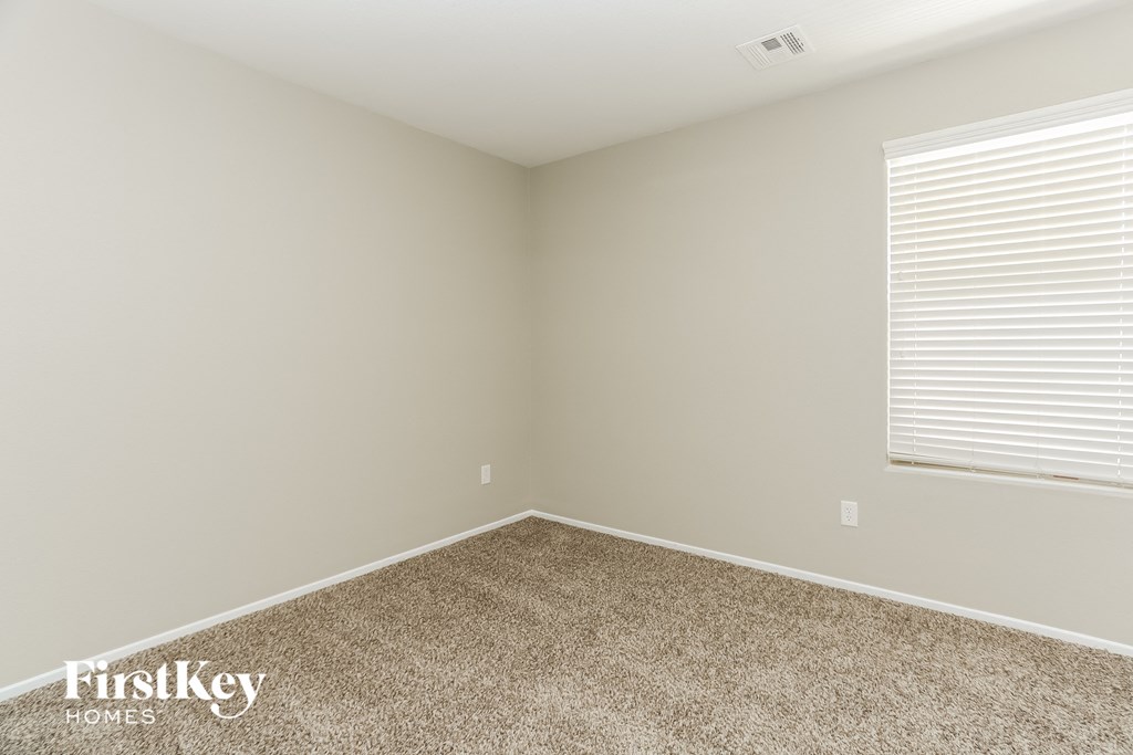 the upstairs bedroom has carpet and a large window