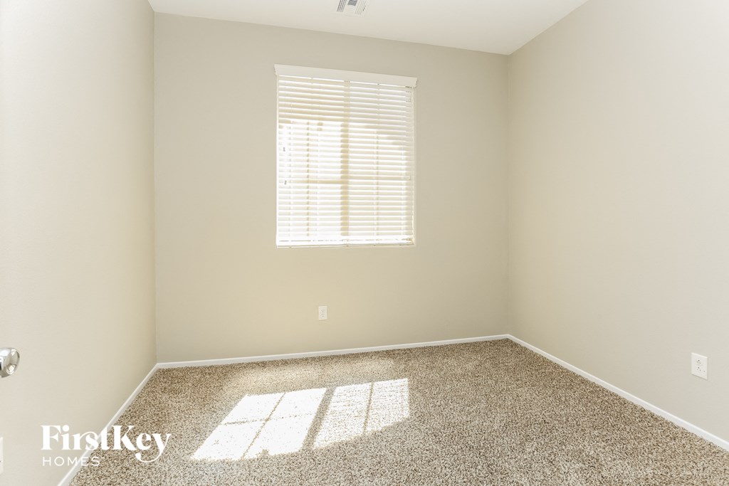 a empty room with a window and a carpet