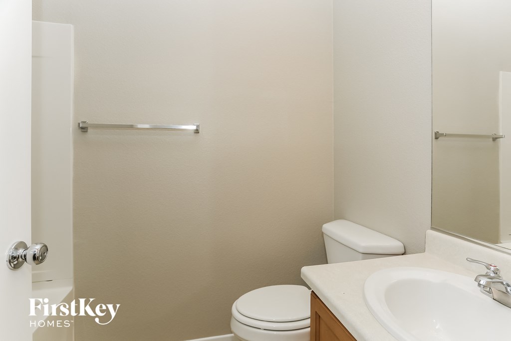 a bathroom with a sink toilet and a mirror