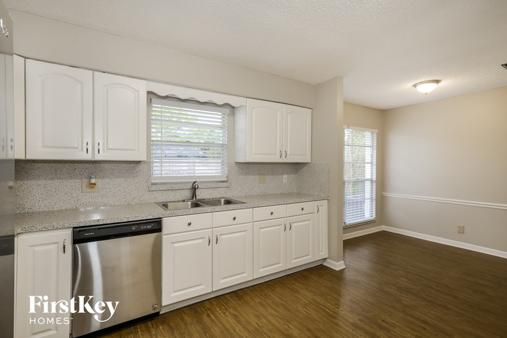 A kitchen with white cabinets and a stainless steel dishwasher.