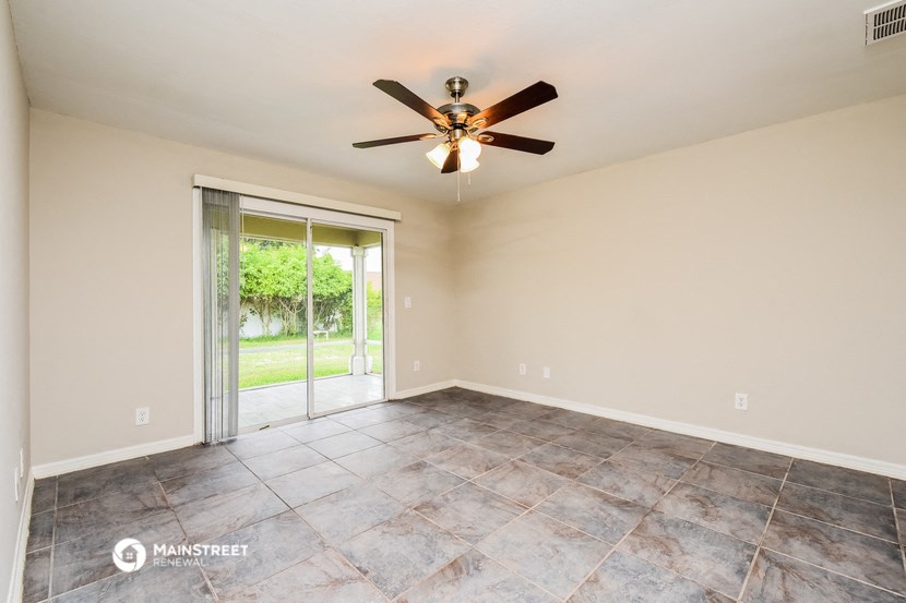 the spacious living room with sliding glass doors to the backyard