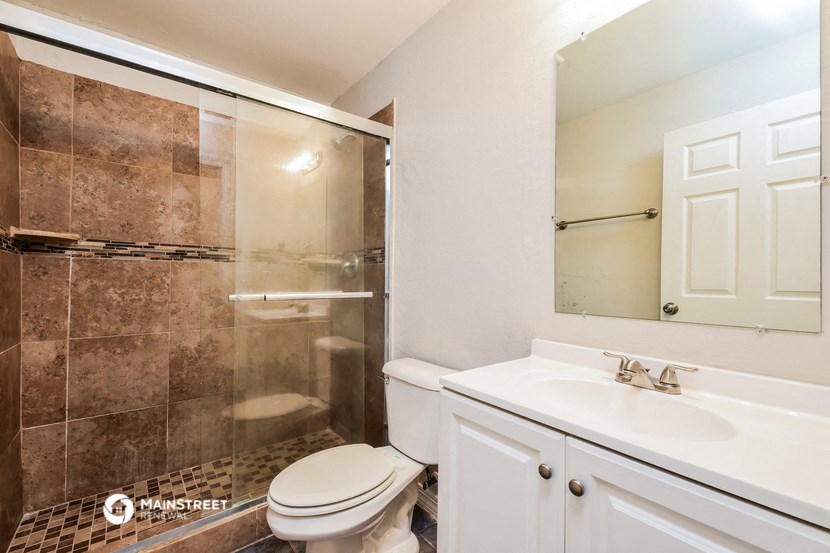 a white bathroom with a shower toilet and sink