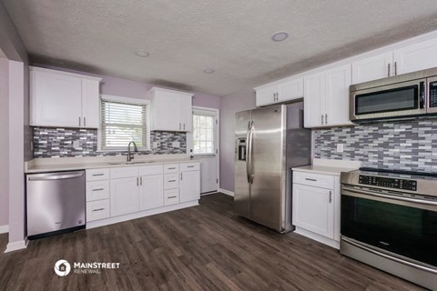 a kitchen with white cabinets and stainless steel appliances