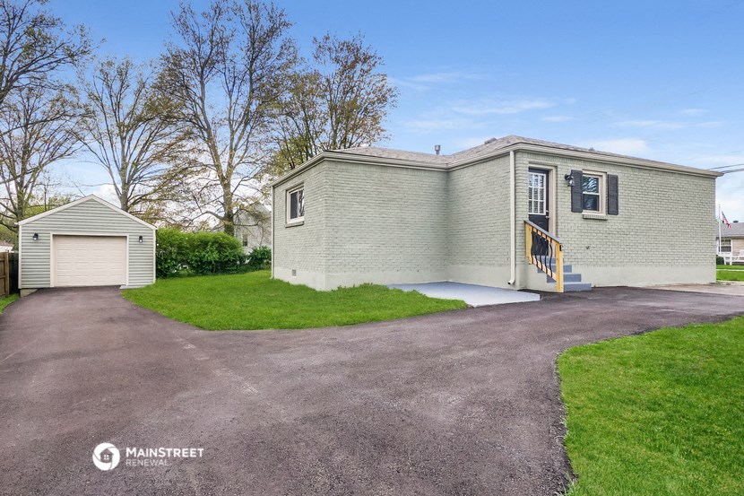 a small white house with a driveway and a garage