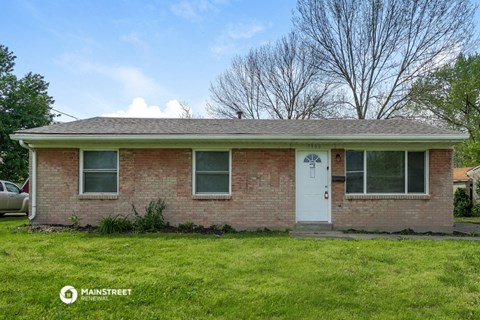 the front of a brick house with a white door