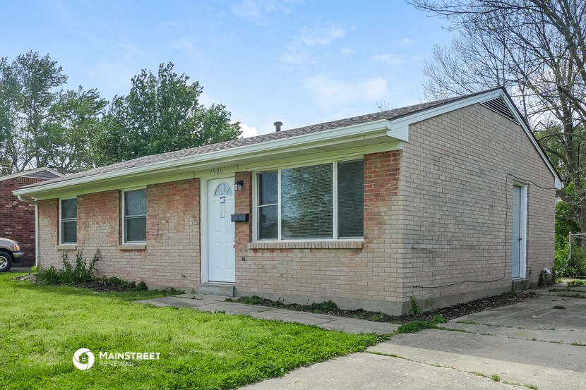 the front of a brick house with a white door