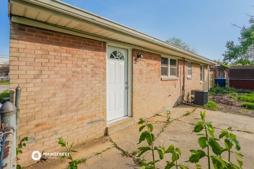 a brick house with a white door and a porch