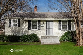 a white house with black shutters and a white door