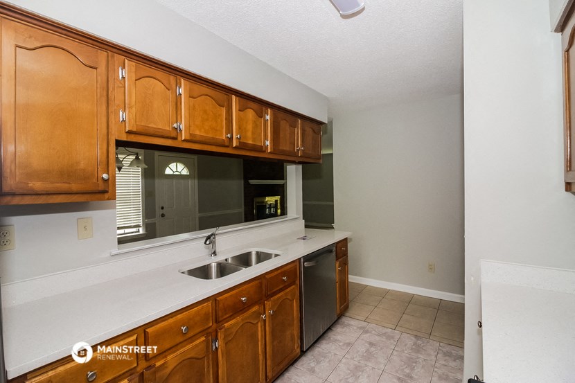 a kitchen with wooden cabinets and a sink and a window