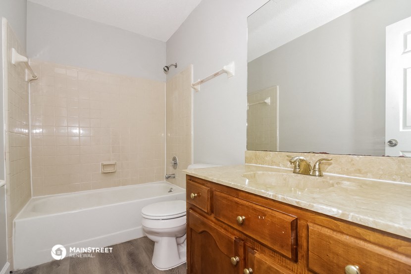 a bathroom with a toilet and a tub and a sink
