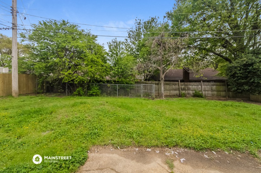 the backyard of a house with a yard and a fence