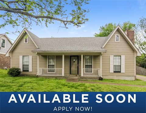 a beige house with a yard and a sign that reads available soon