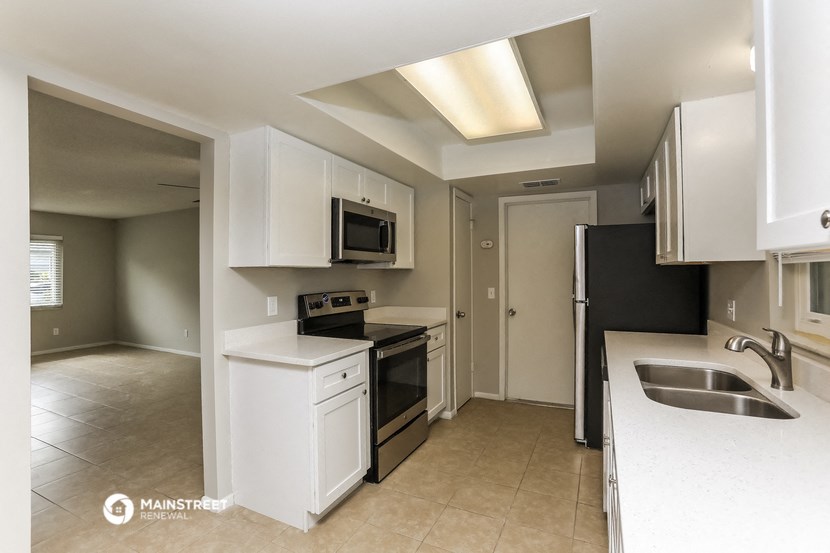 a kitchen with white cabinets and a sink and a stove