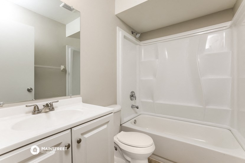 a bathroom with a sink toilet and tub and a mirror