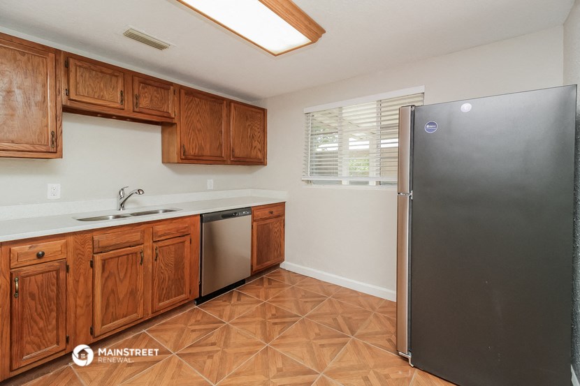 a kitchen with wooden cabinets and a stainless steel refrigerator