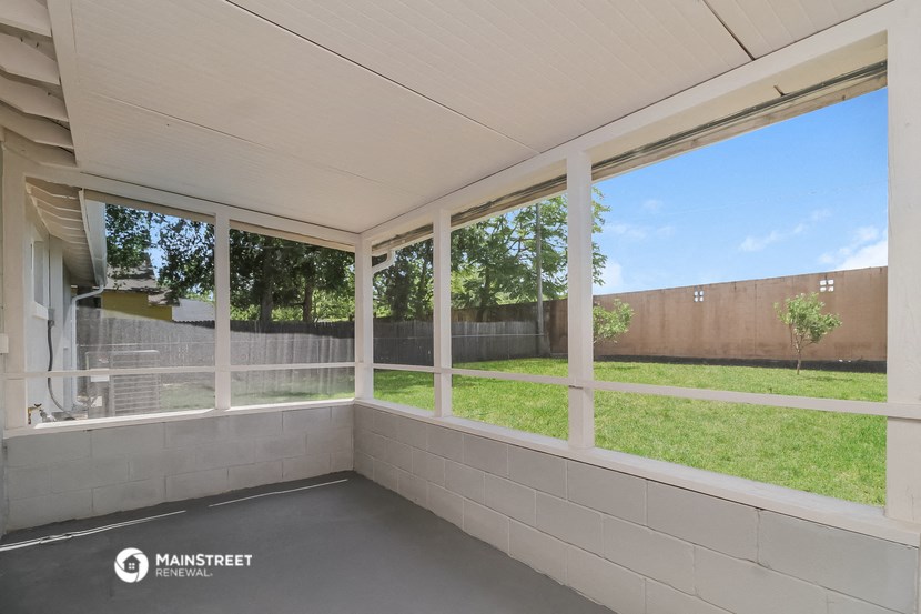 the view of the yard from the screened in porch of a home