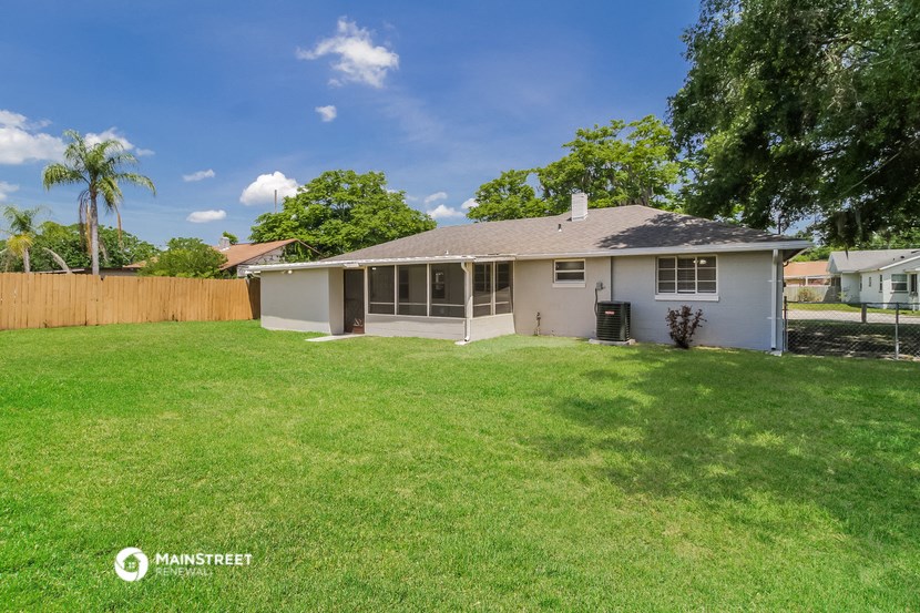 the backyard of a house with a lawn and a fence