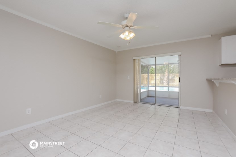 an empty living room with a ceiling fan