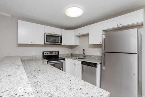 a kitchen with granite counter tops and stainless steel appliances