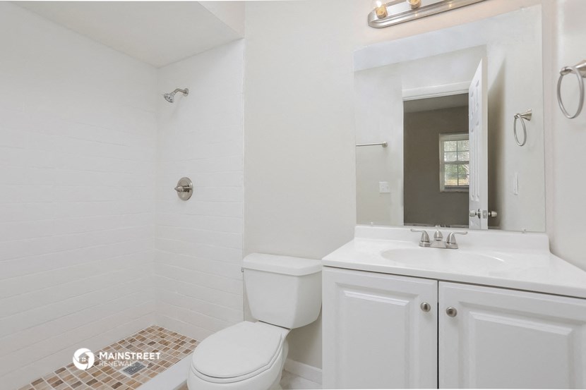 a white bathroom with a toilet and a sink
