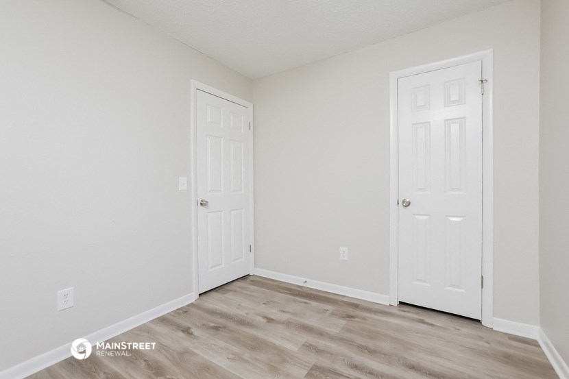 the spacious living room with two doors to the closet