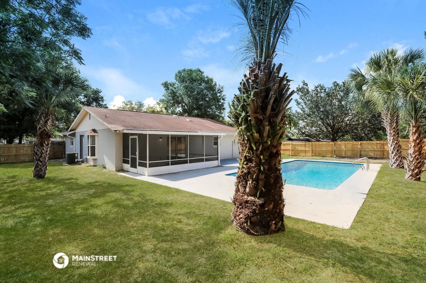 a backyard with a pool and palm trees
