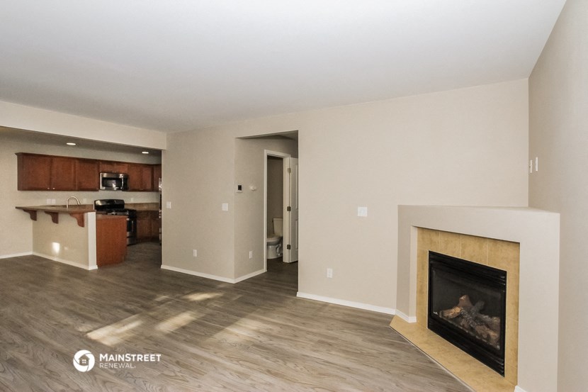 a living room with a fireplace and a kitchen