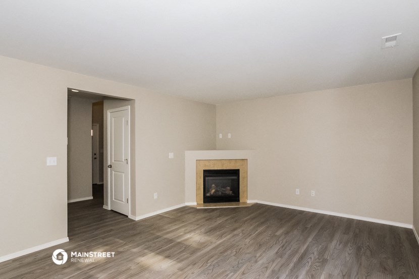 the living room of an apartment with a fireplace