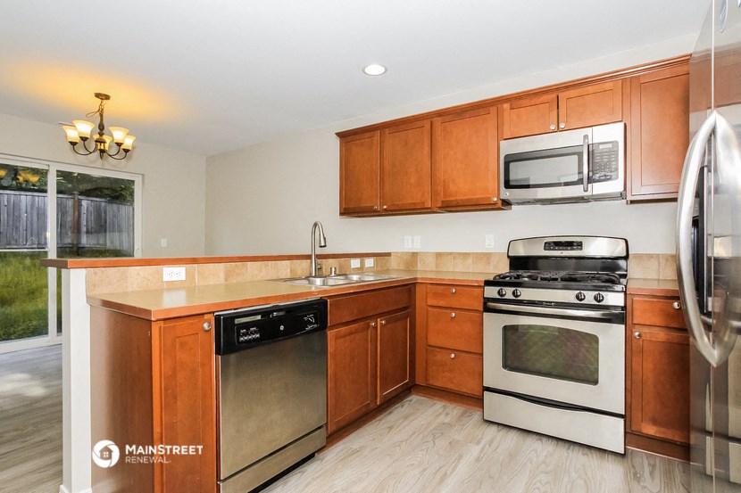 a kitchen with wooden cabinets and stainless steel appliances
