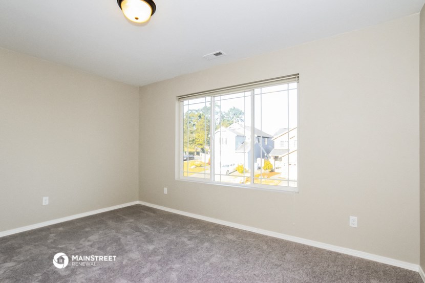 a room with a large window and a carpeted floor