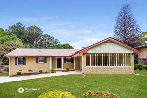 a yellow brick house with a grassy yard and a lawn