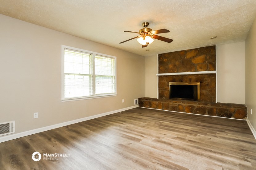 a living room with a fireplace and a ceiling fan