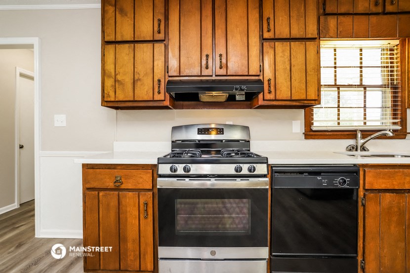 a kitchen with wooden cabinets and a stove and a microwave