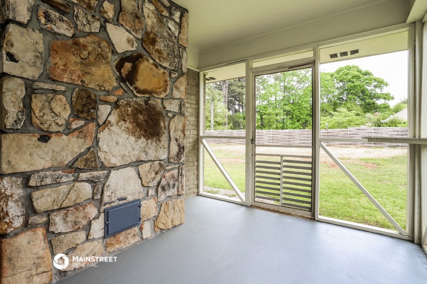 a large stone wall on the side of a house with glass doors