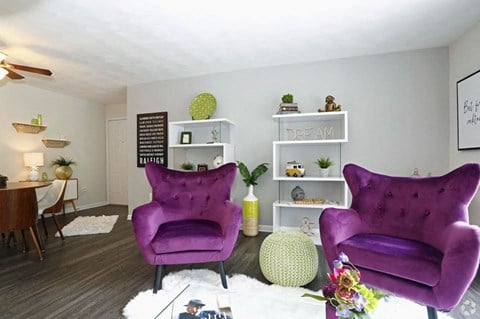 a living room with purple chairs and a table