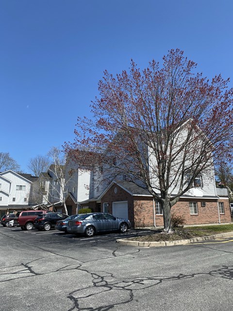 a row of houses with cars parked in a parking lot