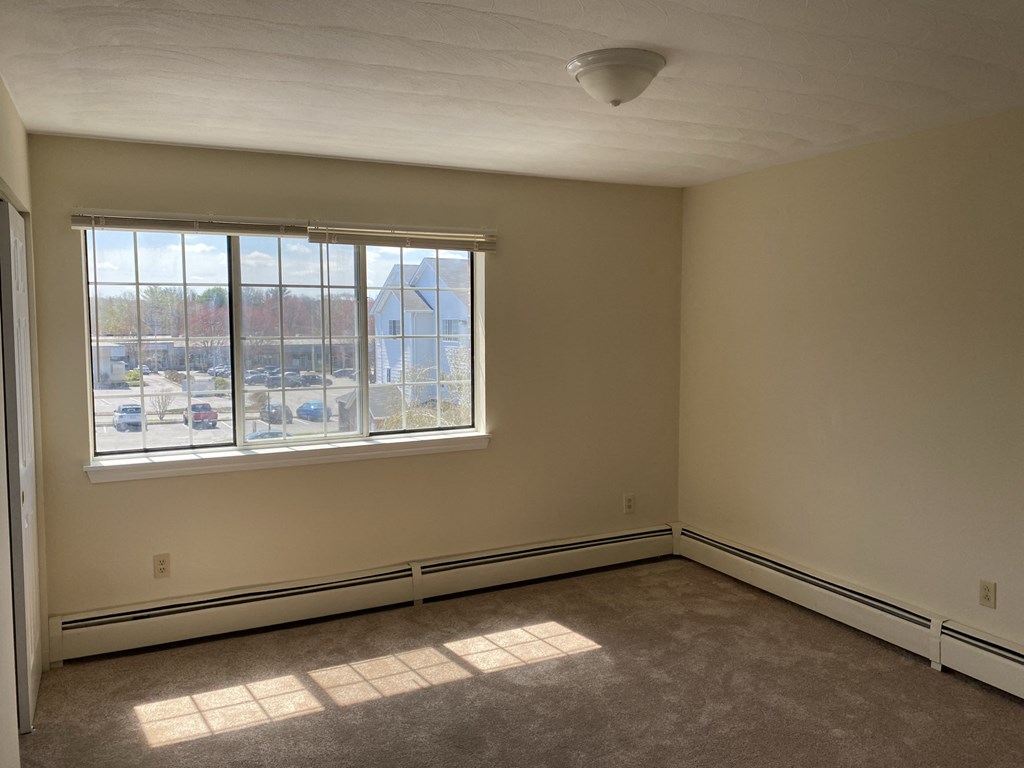 the living room of an empty house with a large window