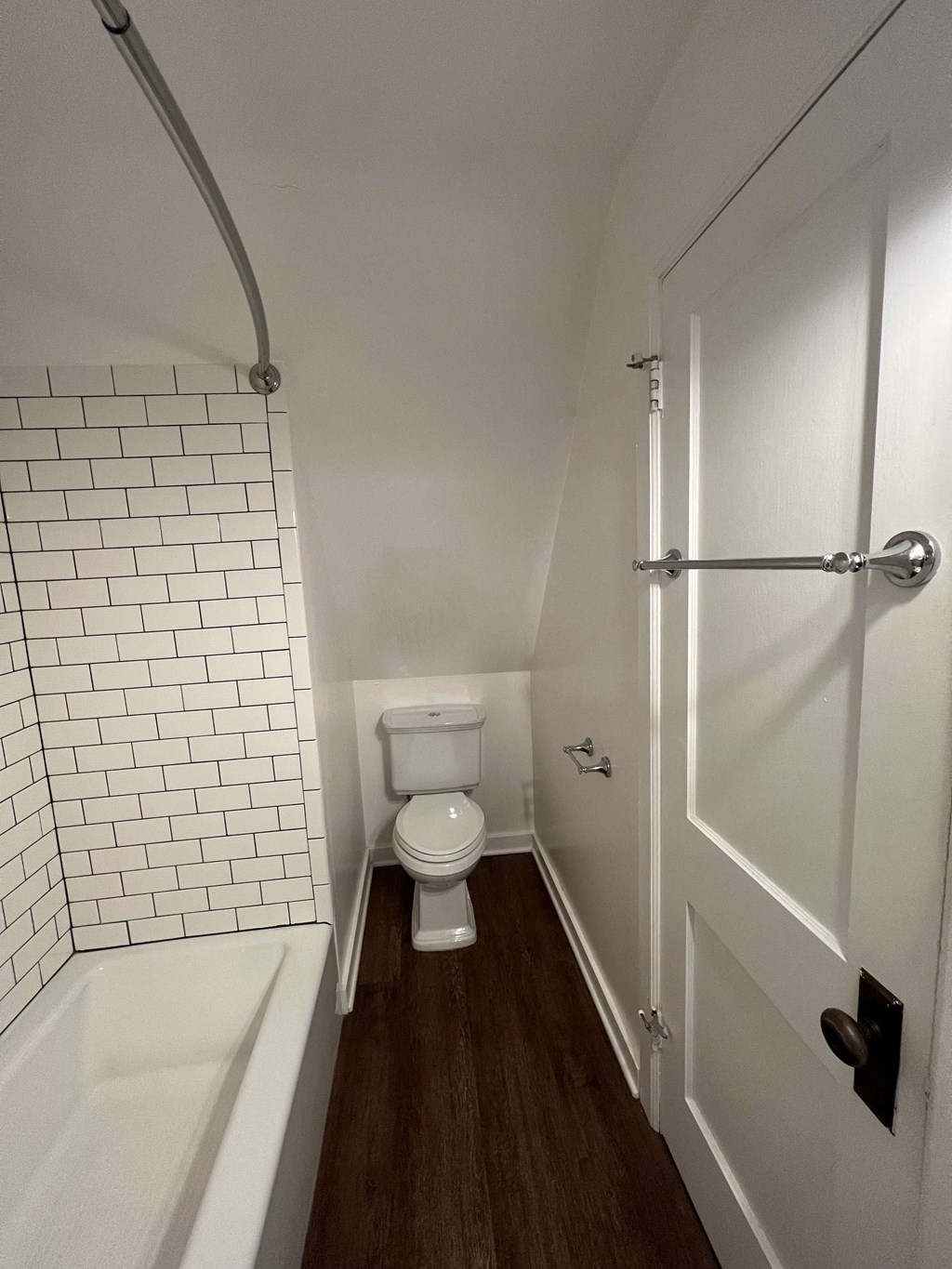 a small bathroom with a toilet and a bath tub