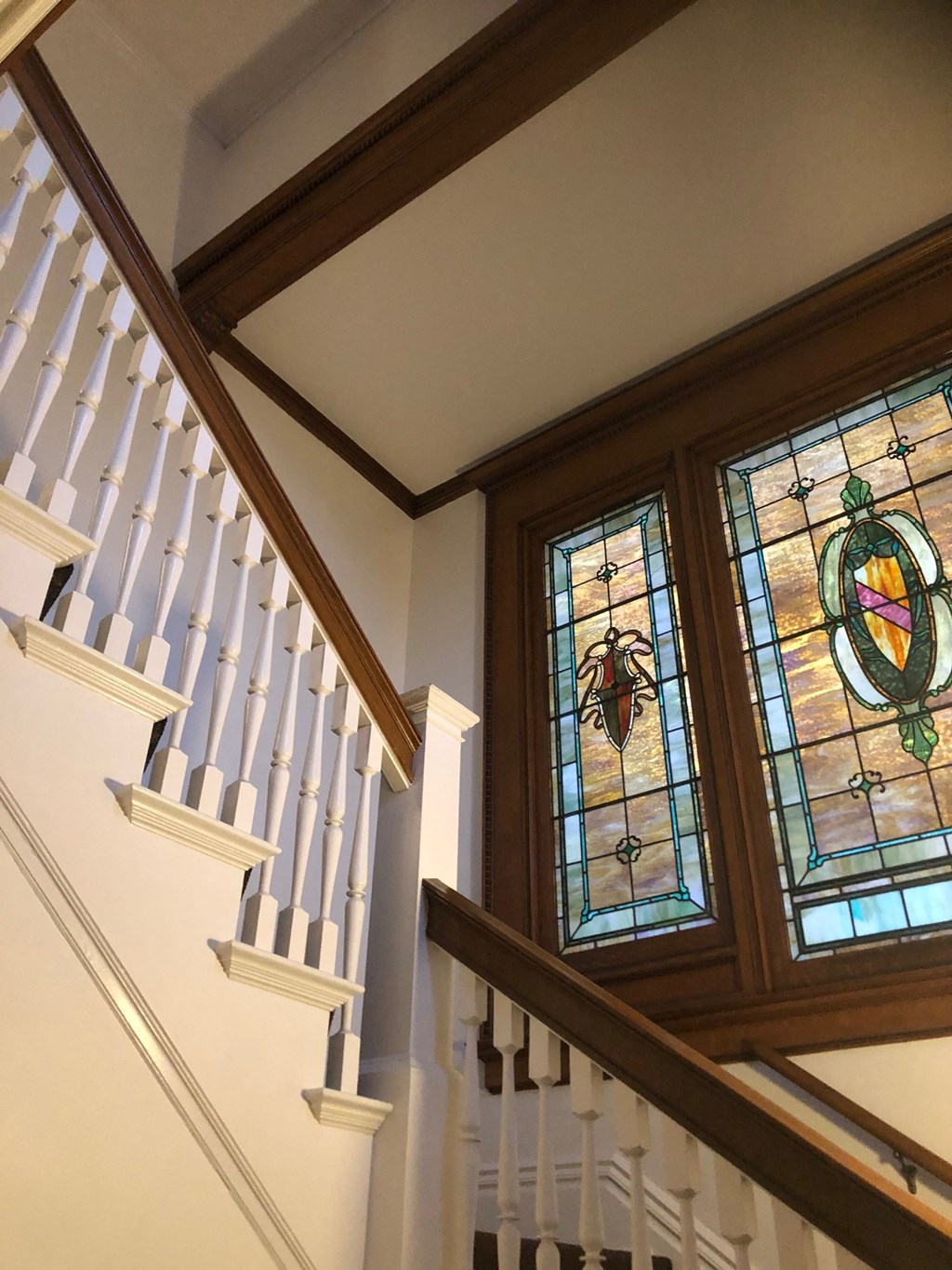 a staircase with a pair of stained glass windows