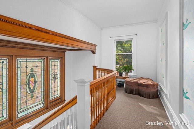 a living room with a staircase and a large window