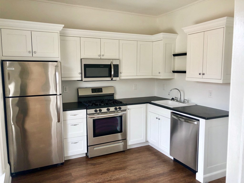 a kitchen with stainless steel appliances and white cabinets