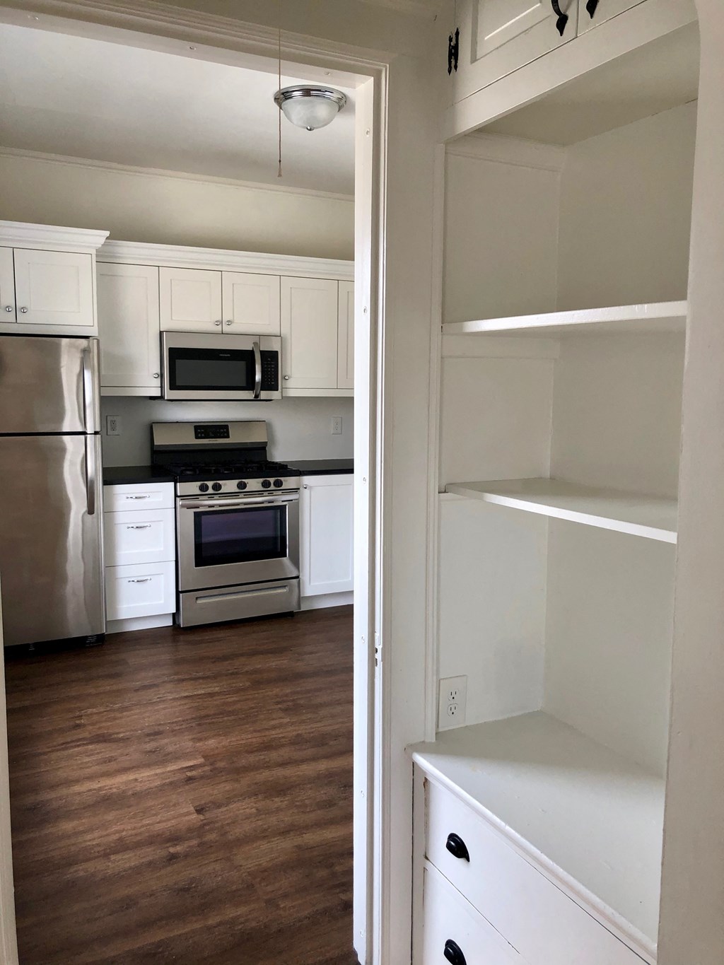 a kitchen with white cabinets and stainless steel appliances