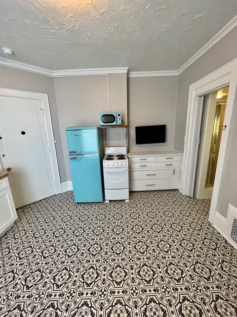 a kitchen with a blue refrigerator and a microwave