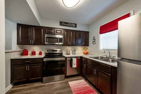 a modern kitchen with dark wood cabinets and stainless steel appliances
