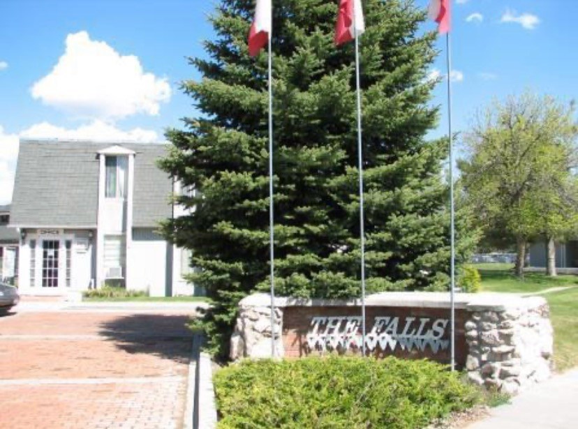 a building with two flags and a sign in front of it