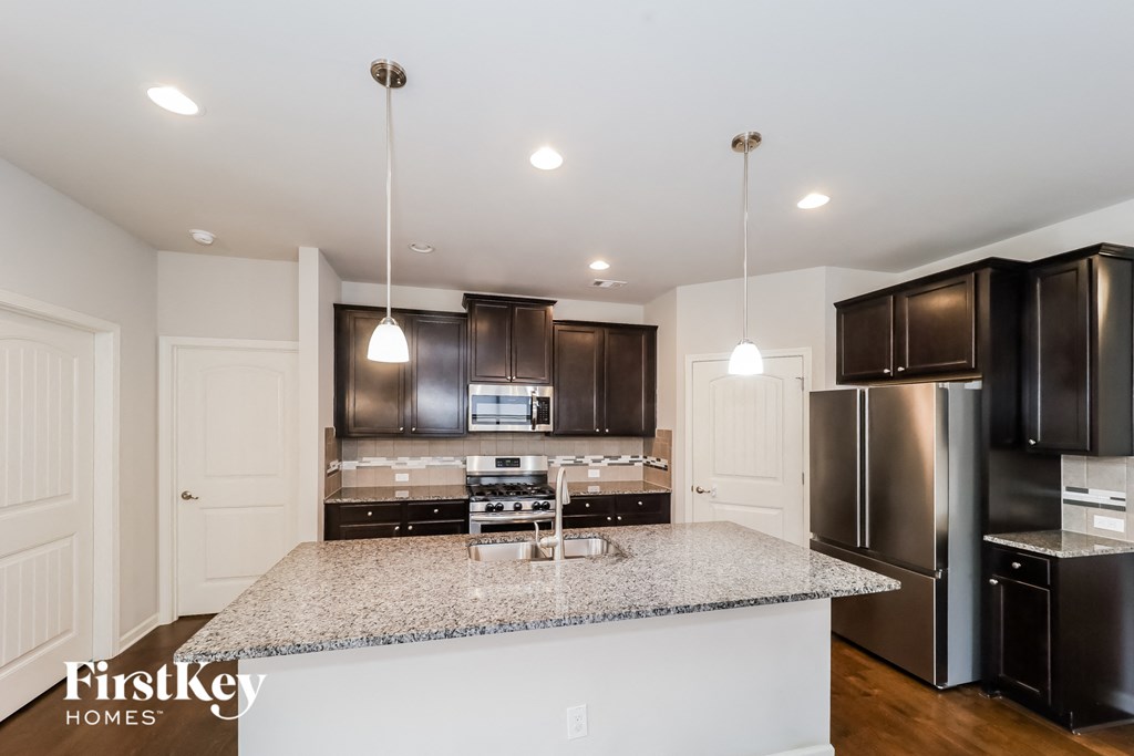 a kitchen with black cabinets and a granite counter top